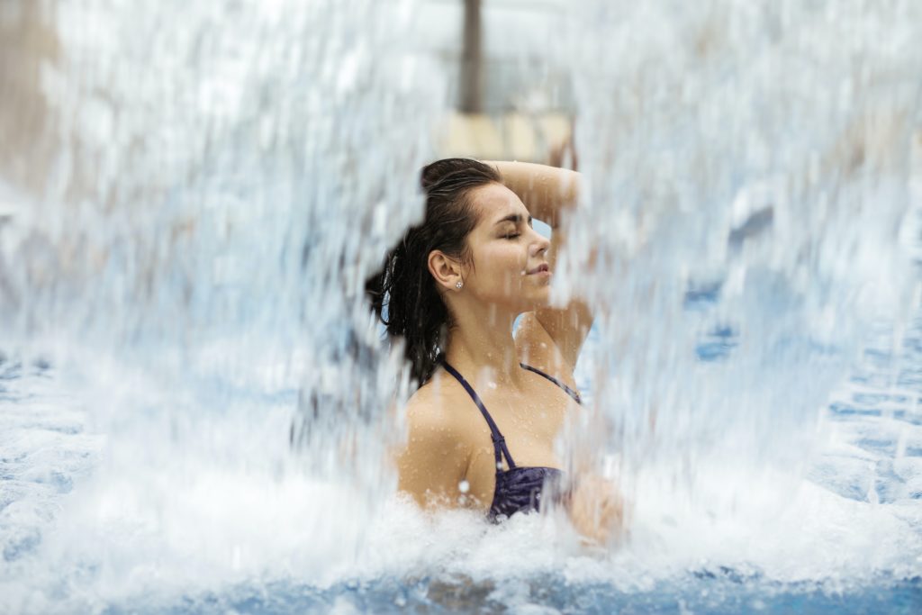woman in spa pool with cascading water