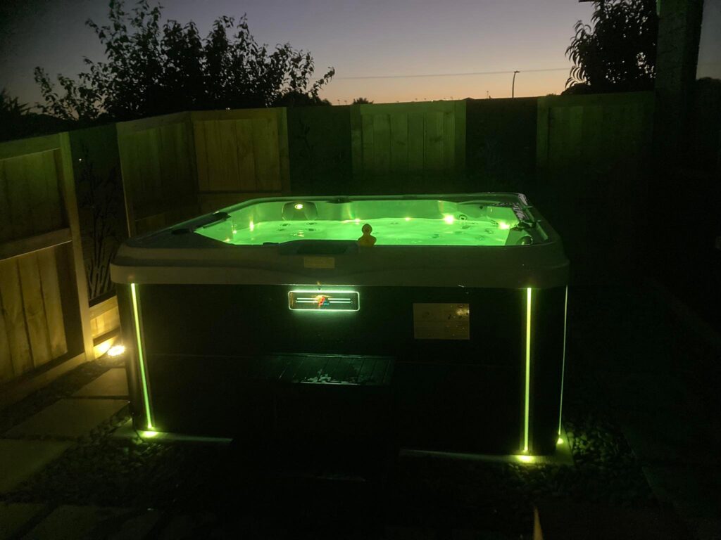 A modern themed spa pool with neon green lights perfect for night time experience. 