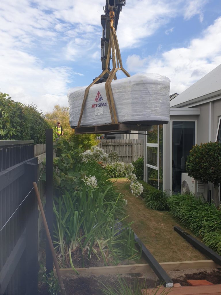 moving a spa pool with a crane into a backyard new zealand