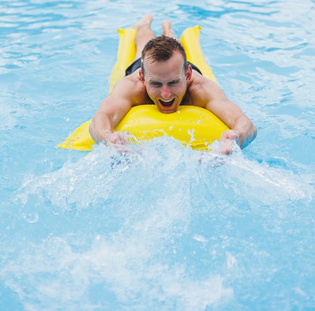 man on yellow lilo in a swim spa pool